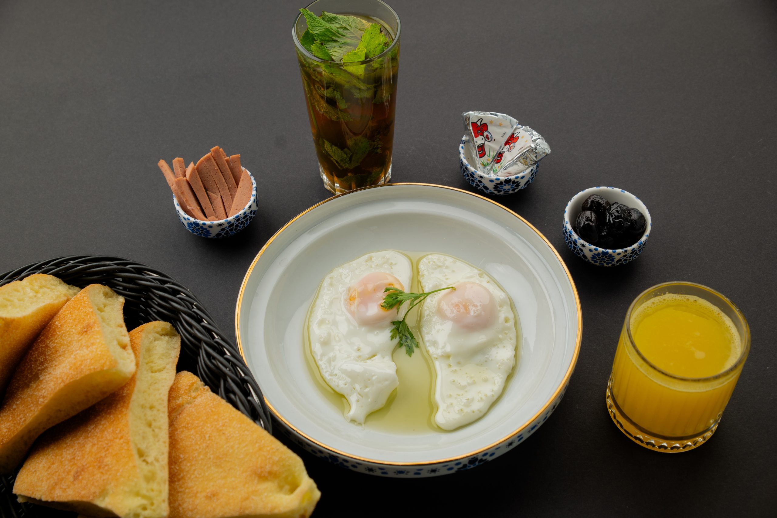 a plate of food with two eggs and a drink
